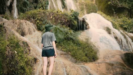 Female-Hiker-Surrounded-By-Beautiful-Multi-Tiered-Waterfalls-Cascading-Through-Erawan-National-Park