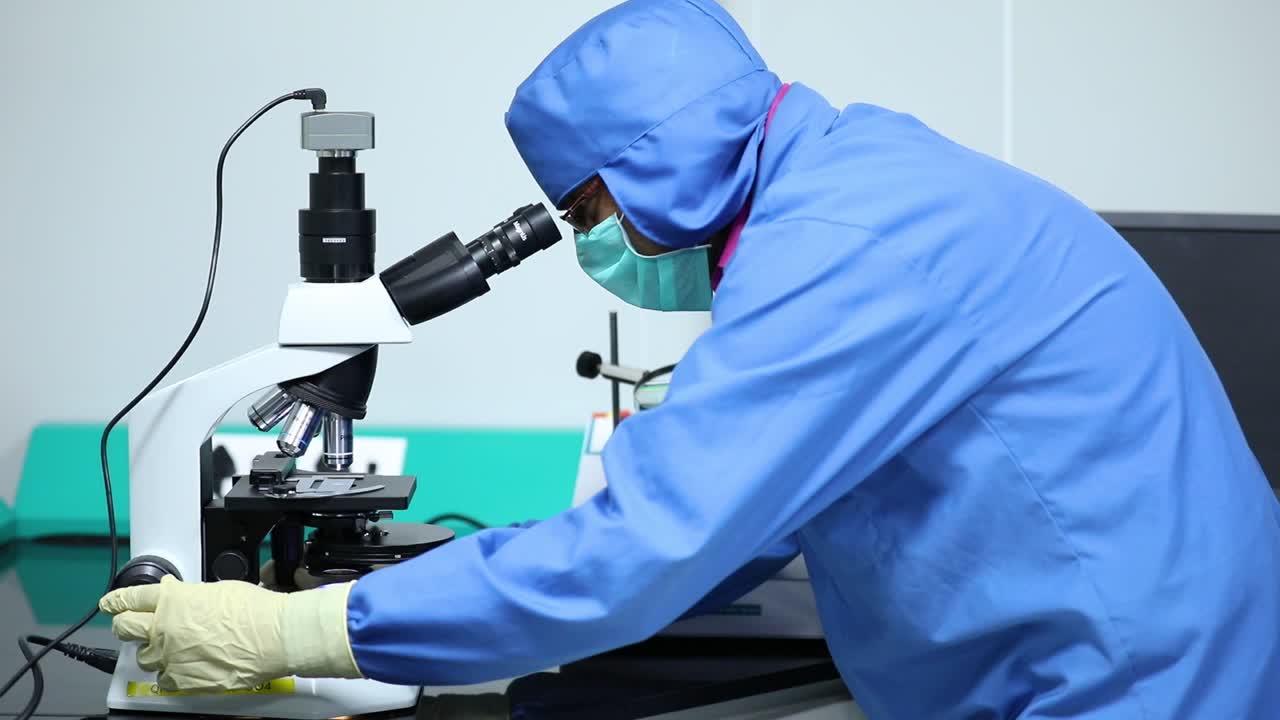 研究室で微鏡を使っている科学者