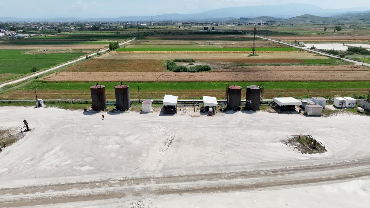 grandes petroleros en el medio de las tierras de cultivo con la aldea cerca causando contaminación