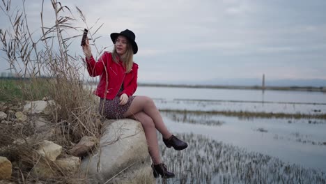 una mujer tomando una selfie junto a un lago.