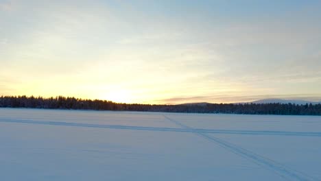 Aerial-view-of-a-winter-landscape-with-forests-and-mountains-at-sunset-in-Gällivare,-in-northern-Sweden