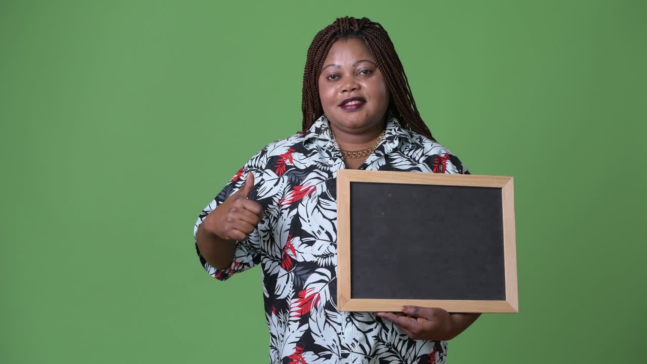 Overweight beautiful African woman against green background