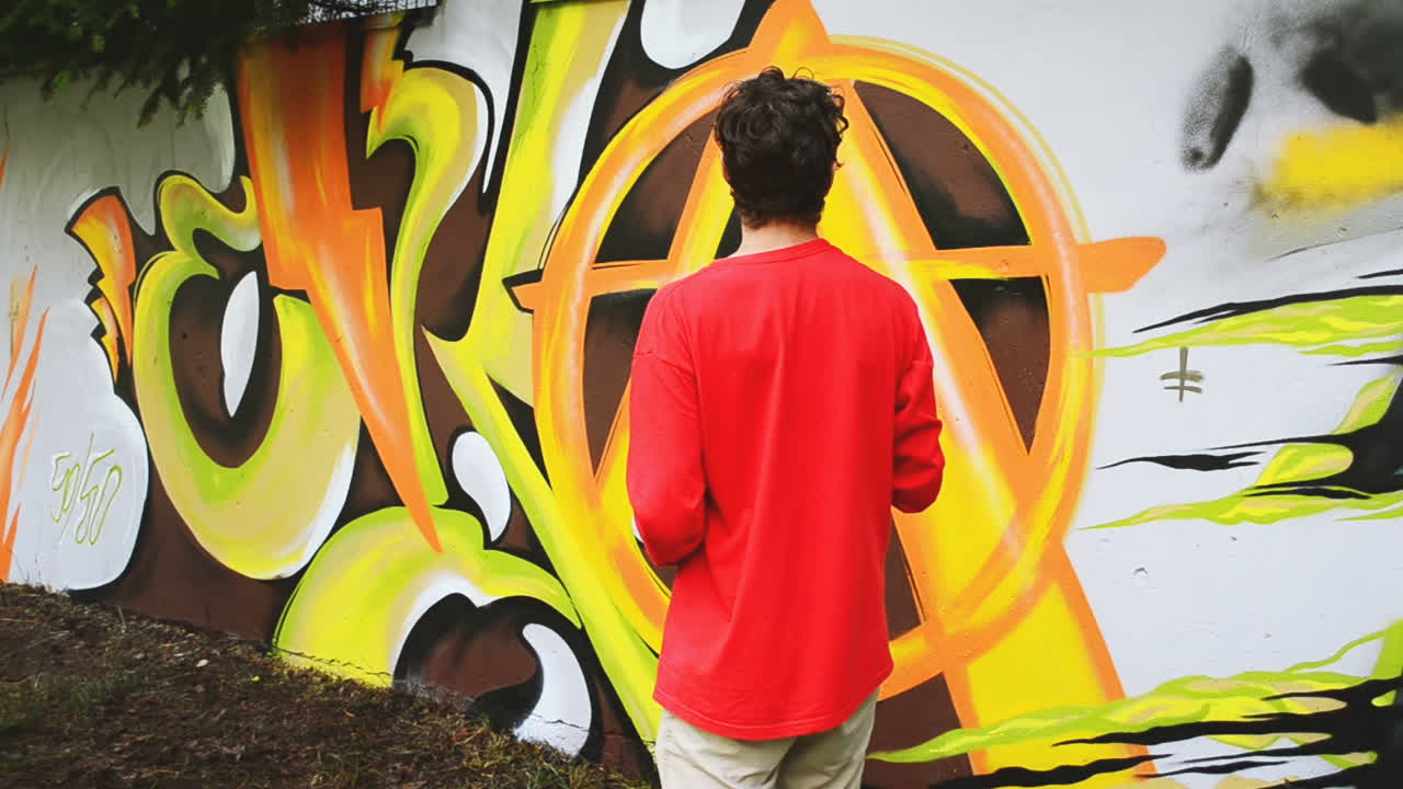 El artista pinta grafitis en una valla. Dibujo abstracto.
