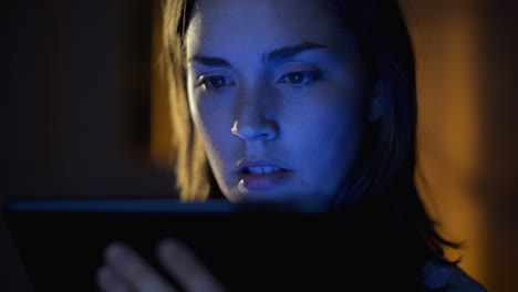mujer leyendo en la tableta por la noche