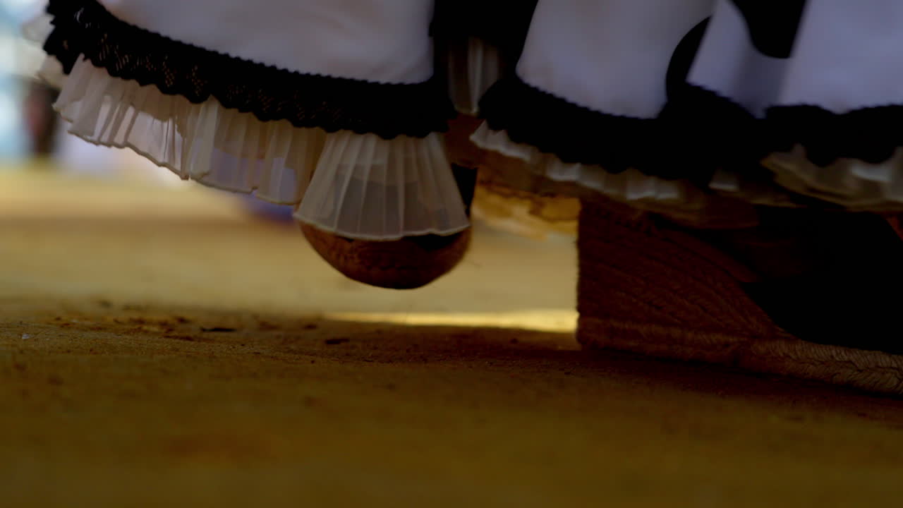 Traditional flamenco shoes and dresses stamping rhythm on the Feria ground