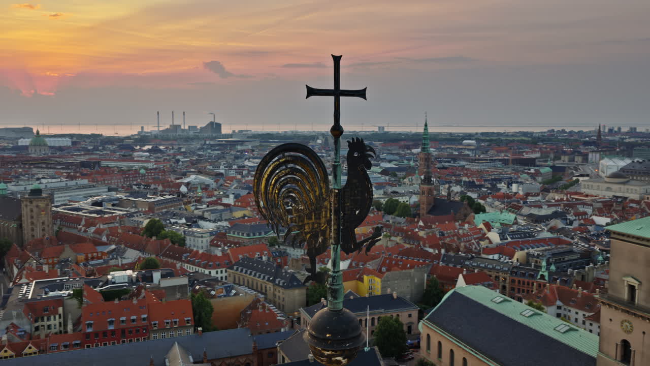 Aerial drone view of rooster weather vane with panoramic view of Copenhagen rooftops, Denmark
