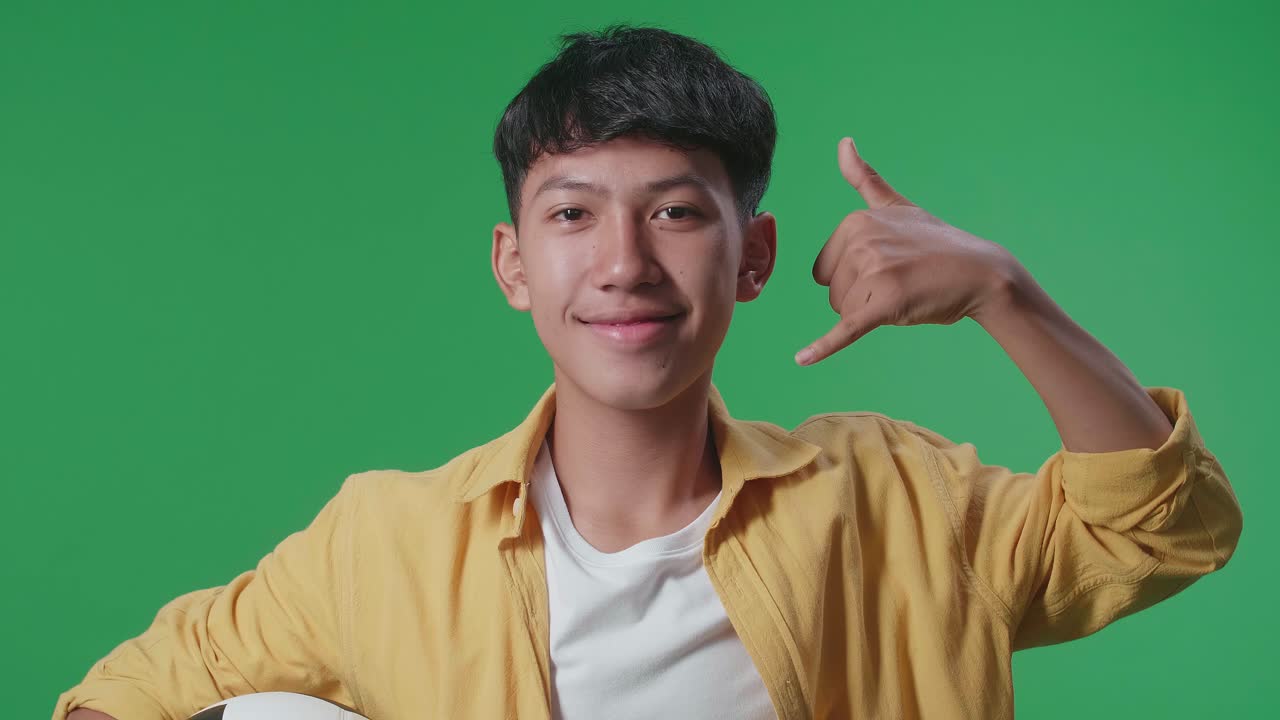 십대 가 축구 공 을 들고 전화 로 몸짓 을 하고 있다