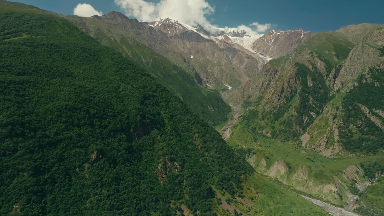 Lush green mountains with Devdoraki Glacier in Kazbegi, Georgia