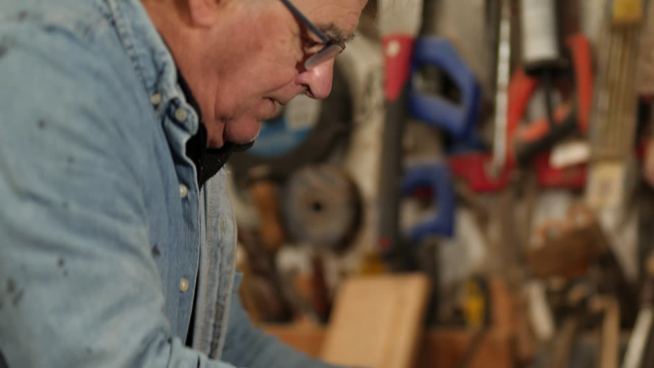 Senior carpenter crafting a smooth surface on a piece of iroko timber