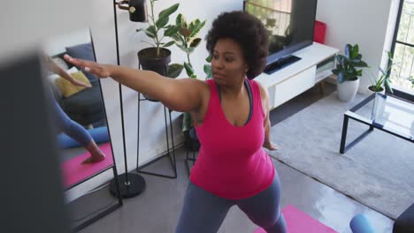 african american female plus size standing on exercise mat working out