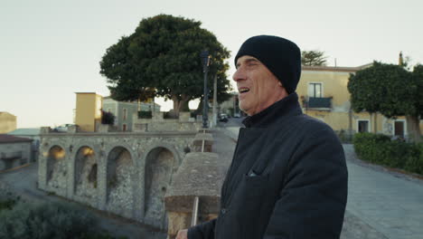 old man looking out from the balcony of his home country looks at the landscape