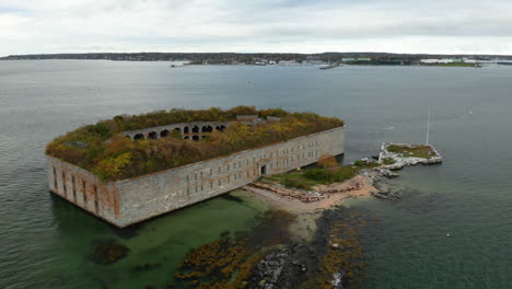 high orbit aerial shot of fort gorges in casco bay with portland, maine in the background