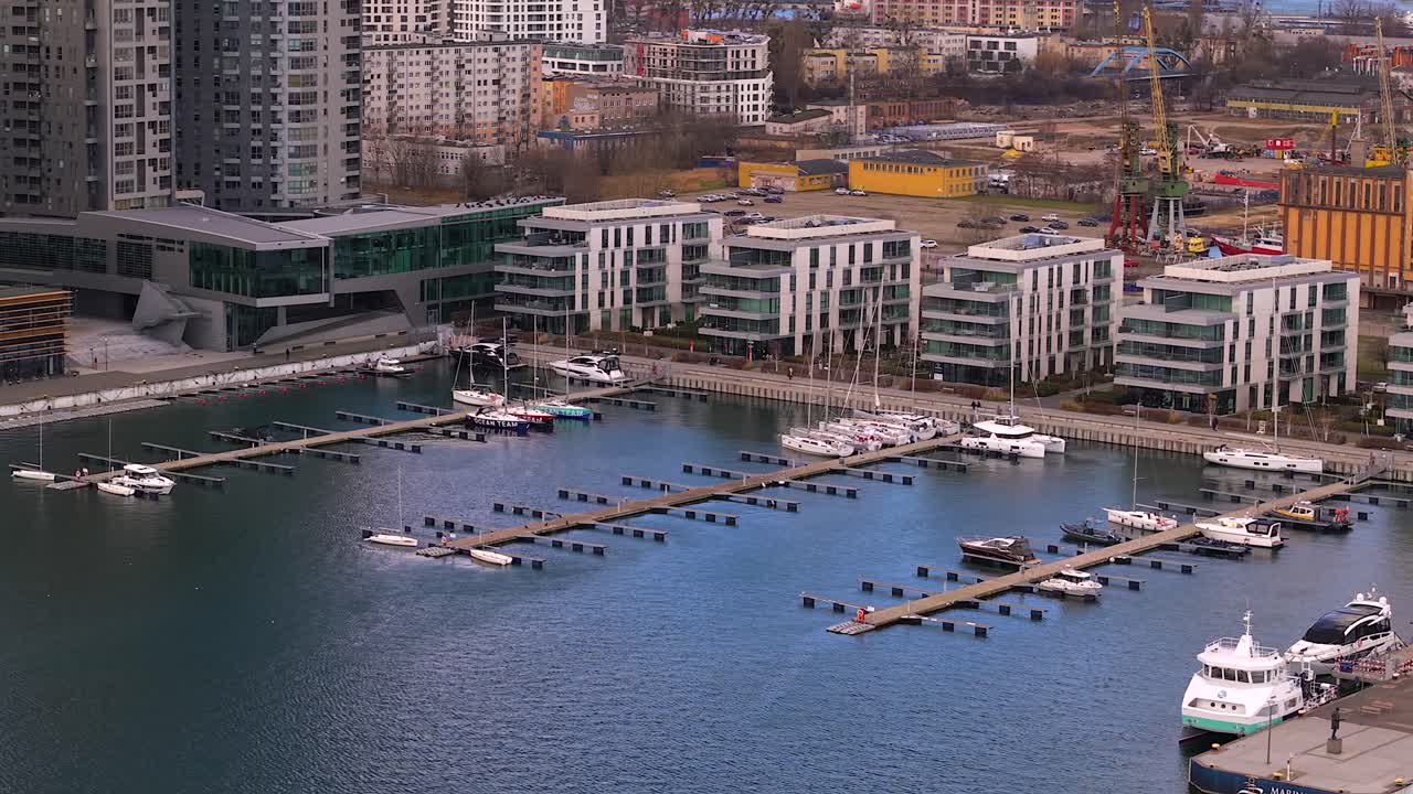 Prospettiva aerea del porto turistico della città di Gdynia, con barche a vela e yacht a motore ormeggiati accanto a moderni edifici residenziali