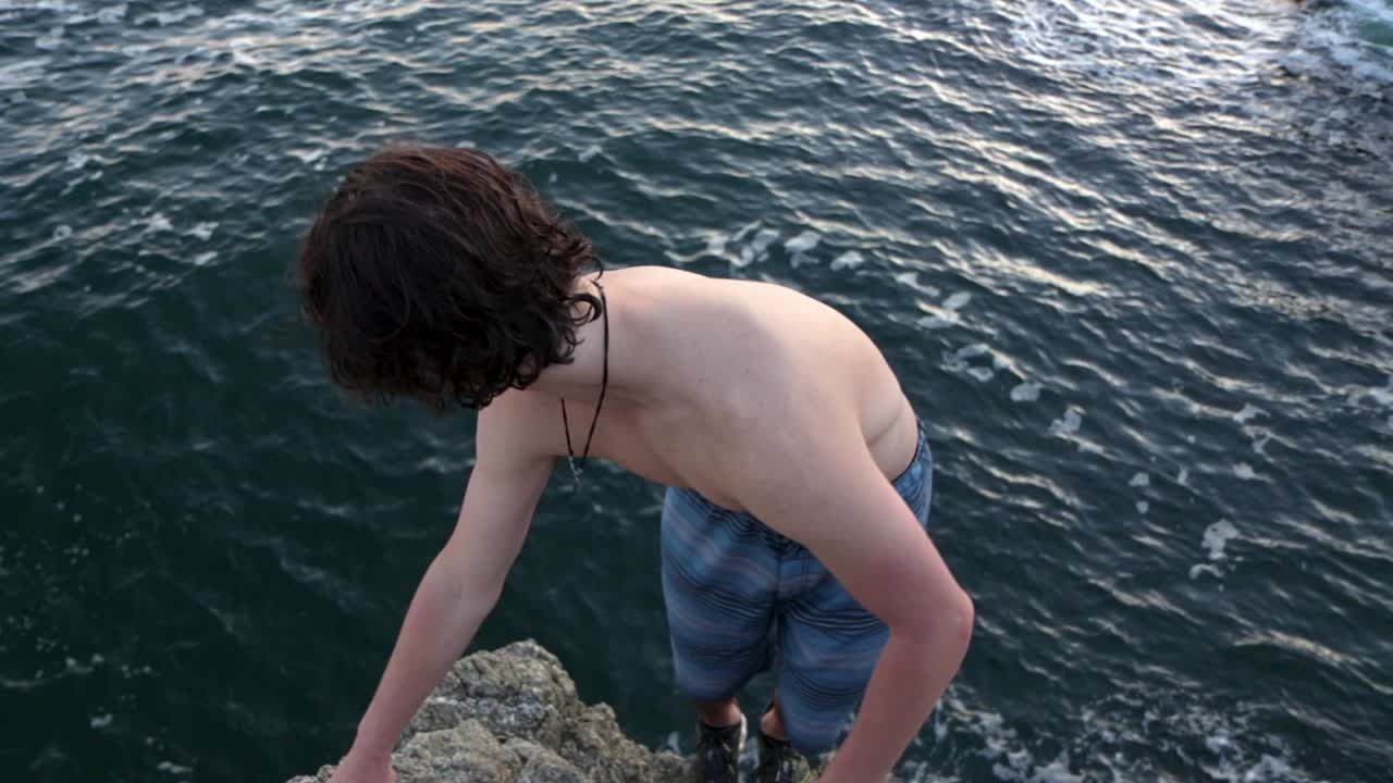 A man jumping off a cliff doing a double backflip
