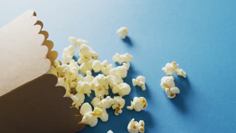 video of close up of box of popcorn on blue background