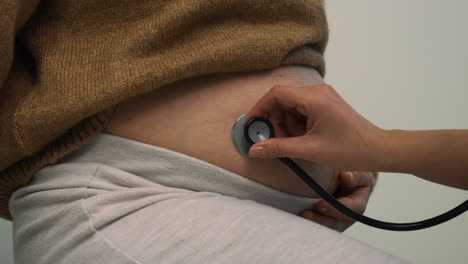 doctor checking pregnant woman's belly