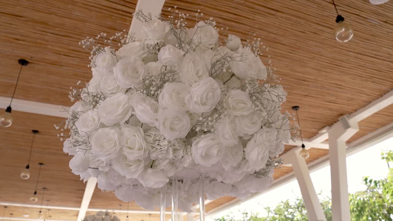 Stunning arrangement of white roses suspended from the ceiling creates a bright and elegant atmosphere at a cafe. Perfect for a celebration or gathering
