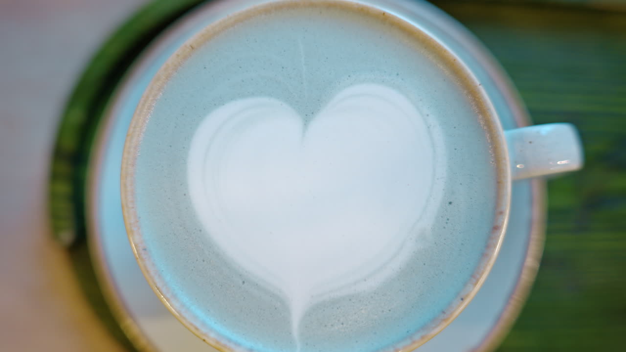 Top down shot of foam latte art on blue matcha drink