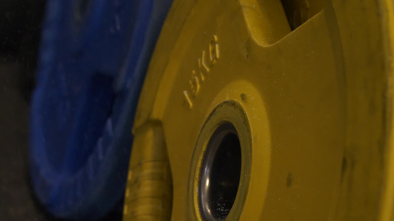 tiza de levantamiento de pesas lloviendo sobre pesas pesadas de gimnasio, pesas amarillas y azules