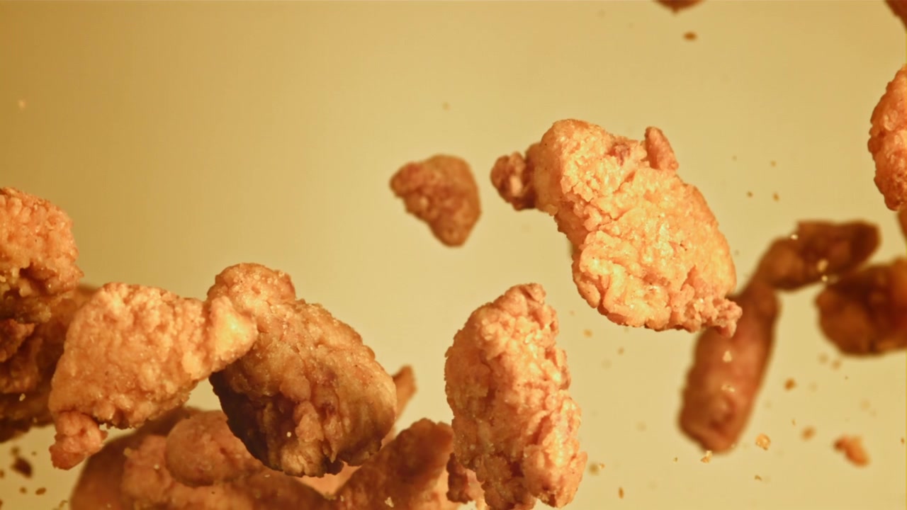 Cena em Câmera Lenta de Nuggets de Frango Fritos Dourados Caindo