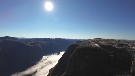 aerial view over naeroyfjord with cloud inversion below, moving toward fetanipa mountain near gudvangen. sunny grand unesco landscape