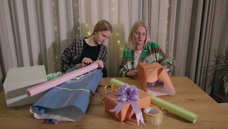 mother and daughter wrapping christmas gifts