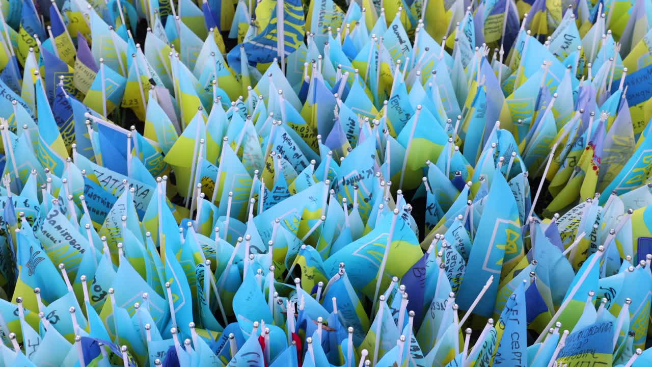 우크라이나에 대한 러시아의 침략에서 죽은 전쟁 병사와 영웅을 기리기 위해 쓰여진 메시지와 함께 우크라이나 기념 발의 필드