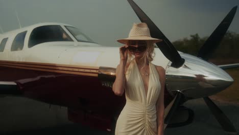 woman in a stylish dress next to a private jet