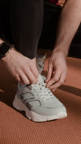 person tying shoelaces before a workout