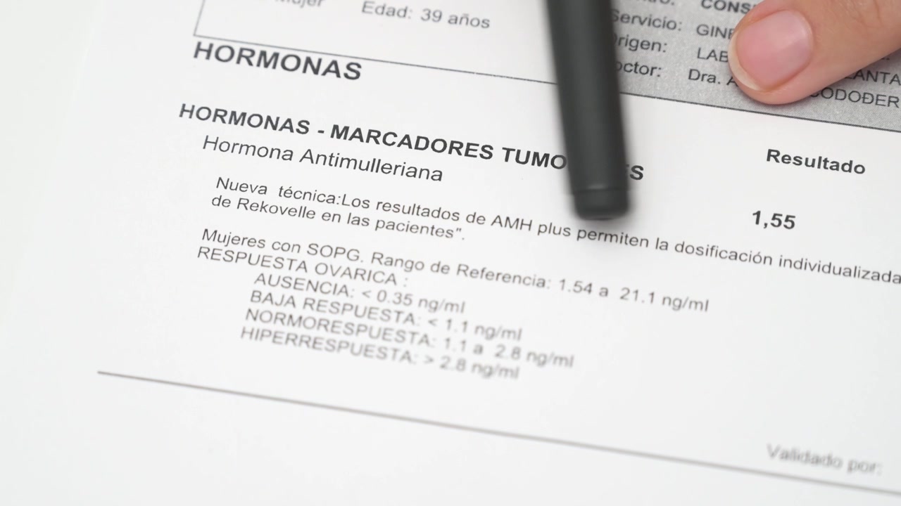 Mujer leyendo sus niveles de hormona antimülleriana - AMH - de un informe de análisis médico