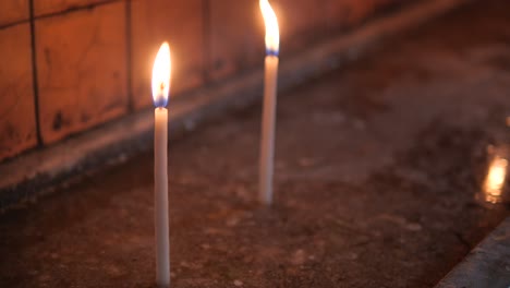 two candles burning brightly in a church