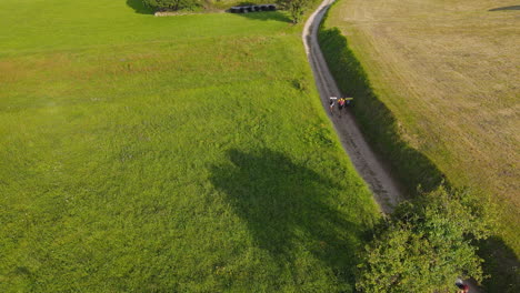 Aerial-View-Of-Group-Of-Three-Pilgrims-Walking-Together-On-Dirt-Road-On-A-Sunny-Day-1