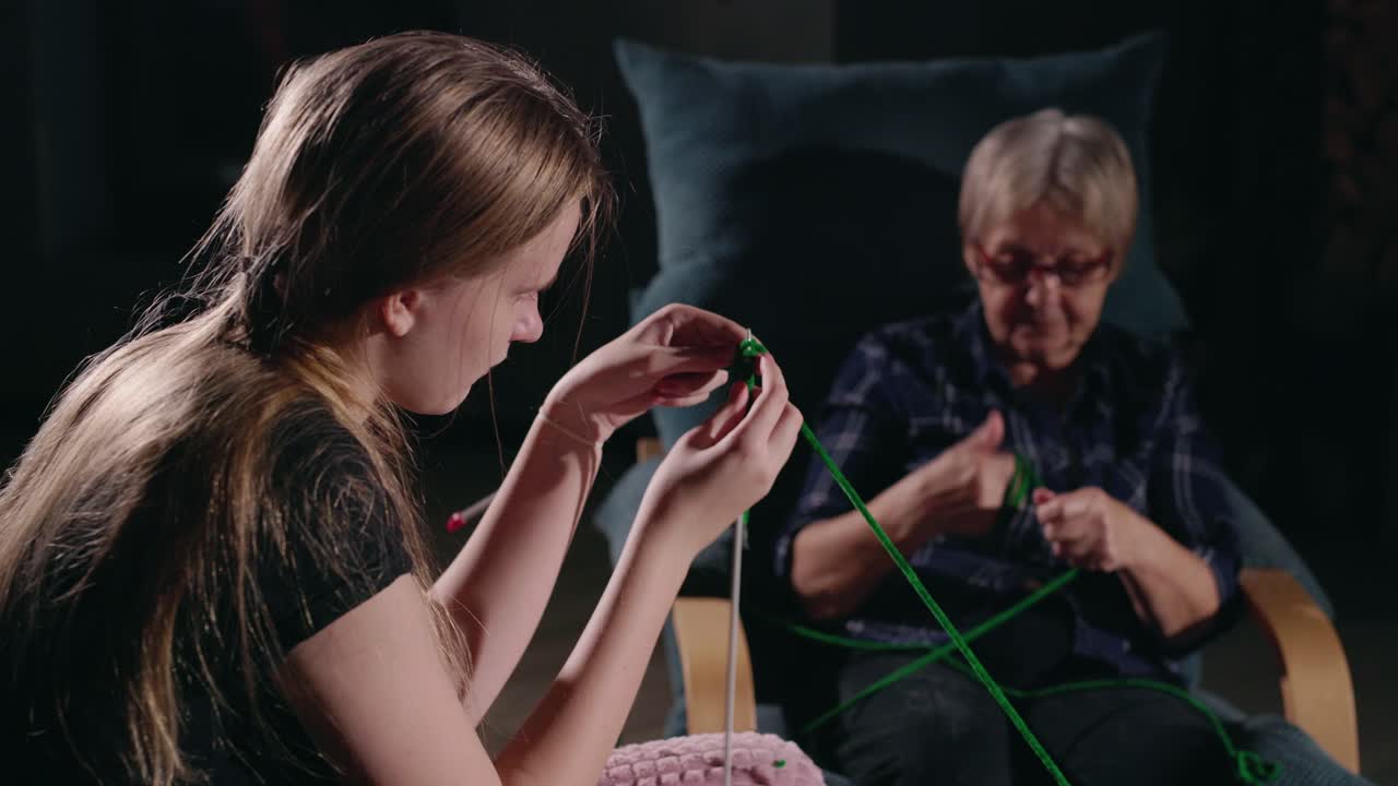 손녀와 할머니가 함께 뜨개질을 합니다.