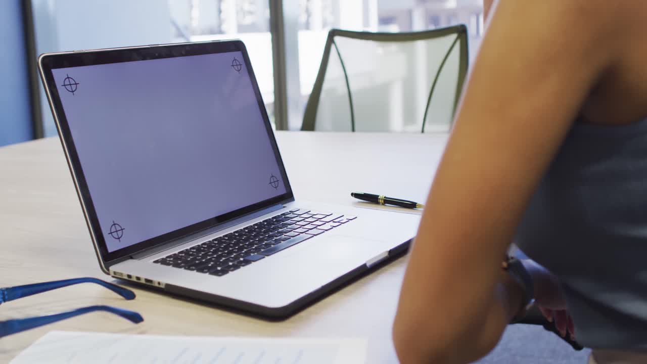 video de una mujer biracial trabajando en una computadora portátil con espacio de copia en la pantalla