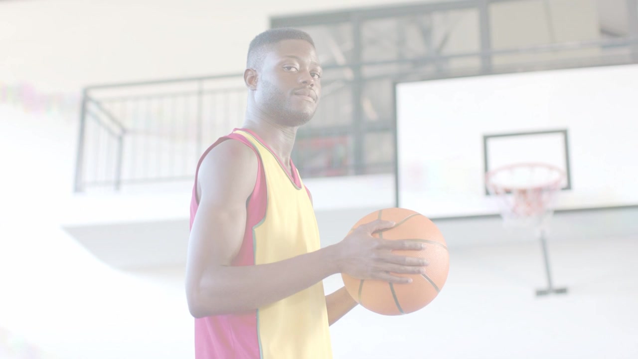 Giocatore di basket maschio di mezza età che tiene la palla vicino al canestro, osserva, regola la presa, prepara il tiro.