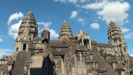 timelapse of temple at angkor wat with blue skies and fluffy white clouds