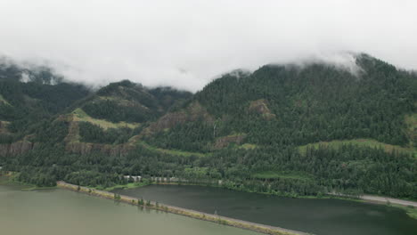 aerial push in towards foothills covered in evergreen trees, columbia river gorge