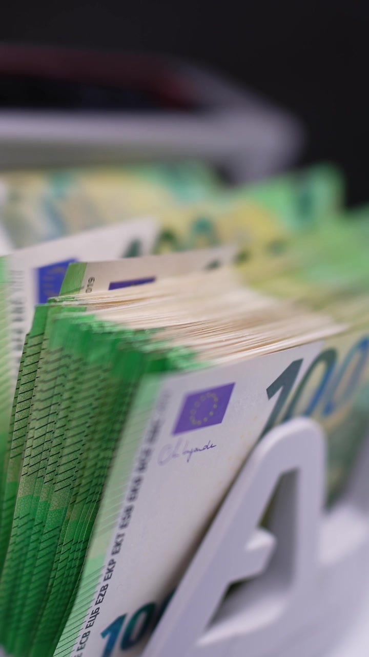 Geldzählmaschine mit Hundert-Euro-Scheinen. Fünfzig-Euro-Banknoten erscheinen nach den Hunderten. Nahaufnahme. Vertikales Video