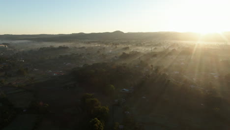 Drohnenschwenkaufnahme-Des-Sonnenaufgangs-über-Ebenen-In-Der-Nähe-Von-Anisakan-In-Myanmar-An-Einem-Nebligen-Morgen
