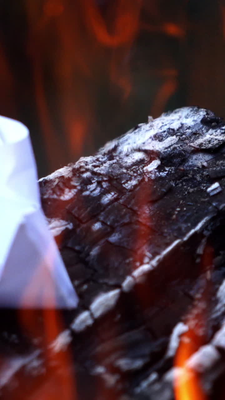 Bonfire. Burning logs in orange flames. Beautiful fire burns brightly. Embers of the fire climb up. Vertical video