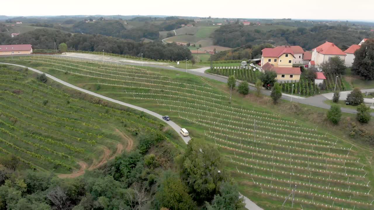 Cars and vans driving through the wine region of Jeruzelum in Slovenia from an aerial perspective