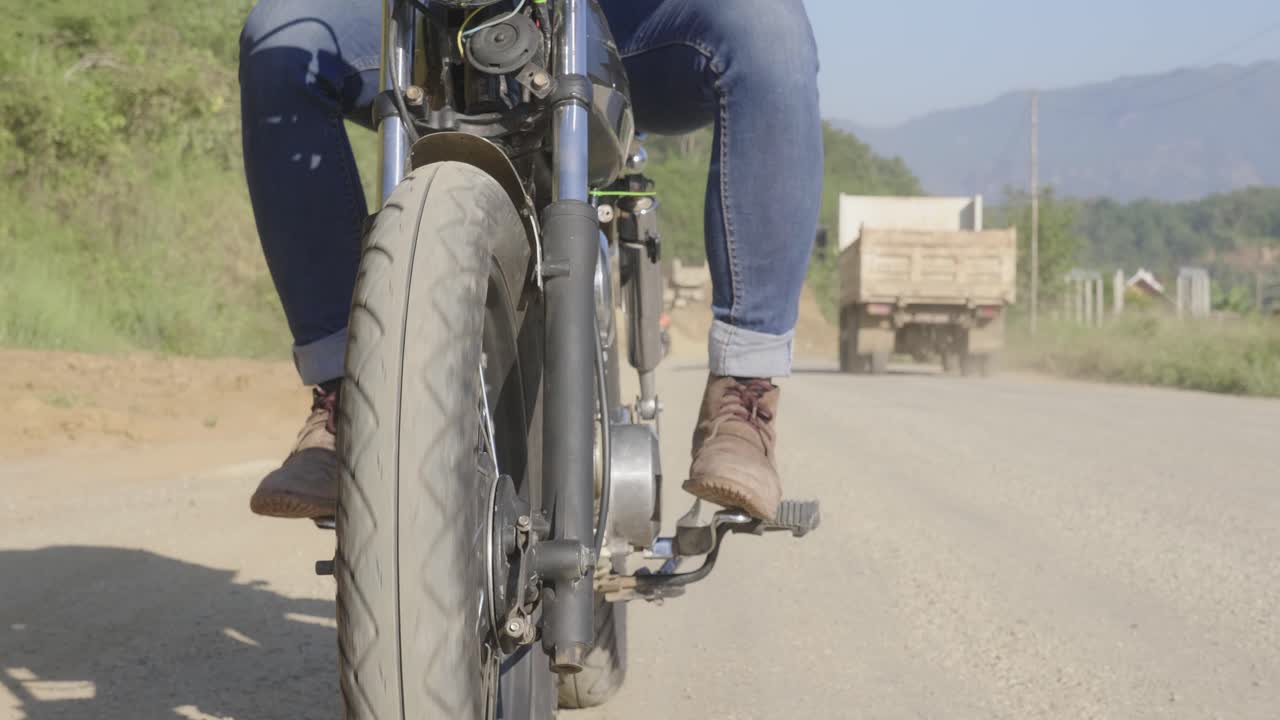 Man Riding a Vintage Motorcycle on a Country Road