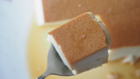 close-up of a piece of caramel custard on a spoon