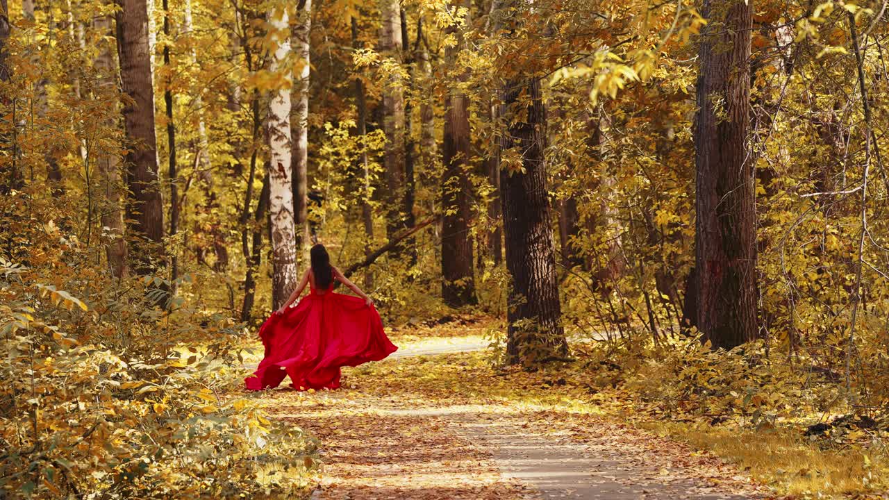 A vibrant scene in an autumn forest, featuring a woman in a flowing red dress dancing gracefully among golden foliage, capturing the essence of nature's seasonal beauty