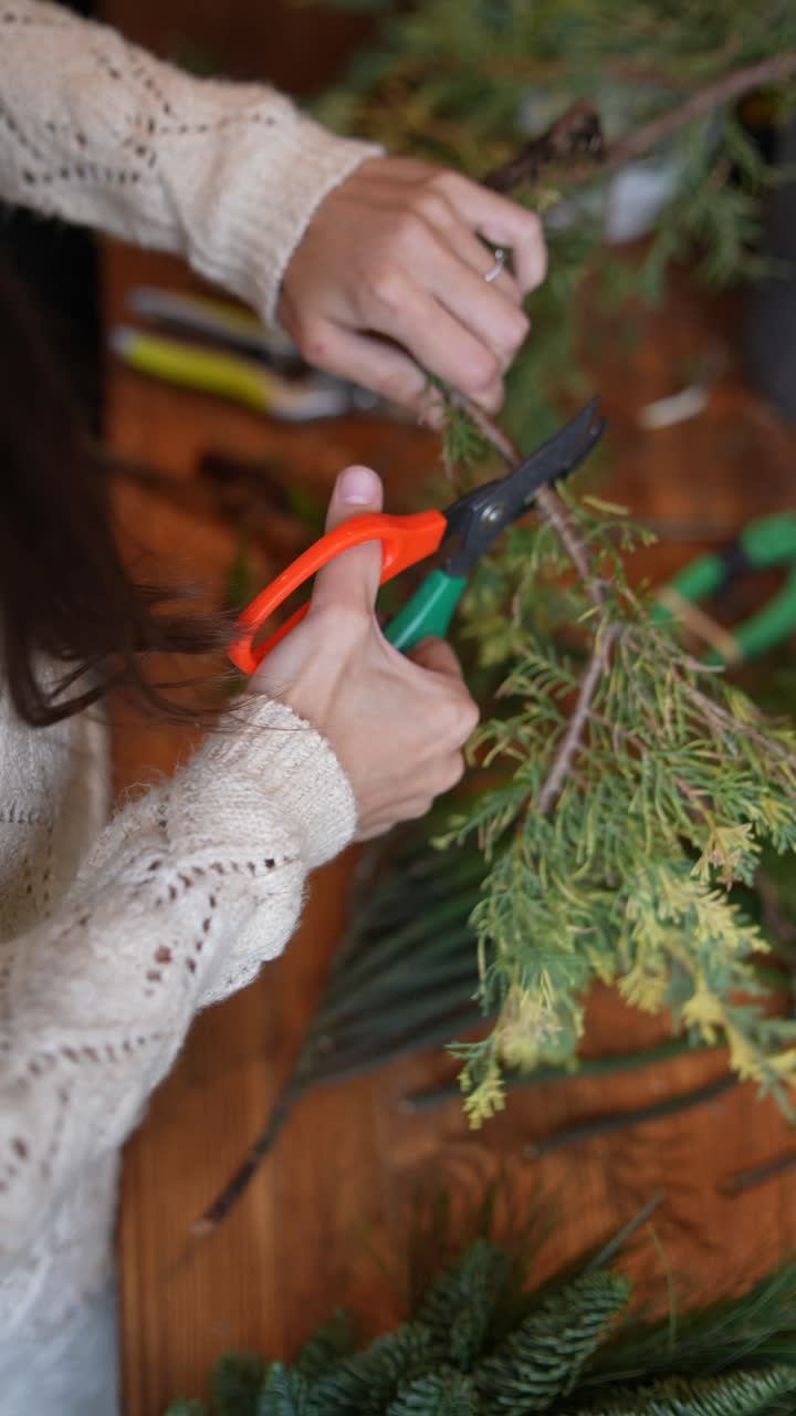 creando un arreglo floral con ramas de hoja perenne
