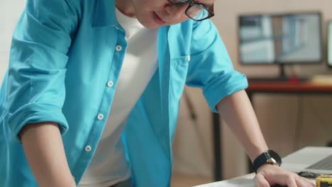 focused asian man working on a project