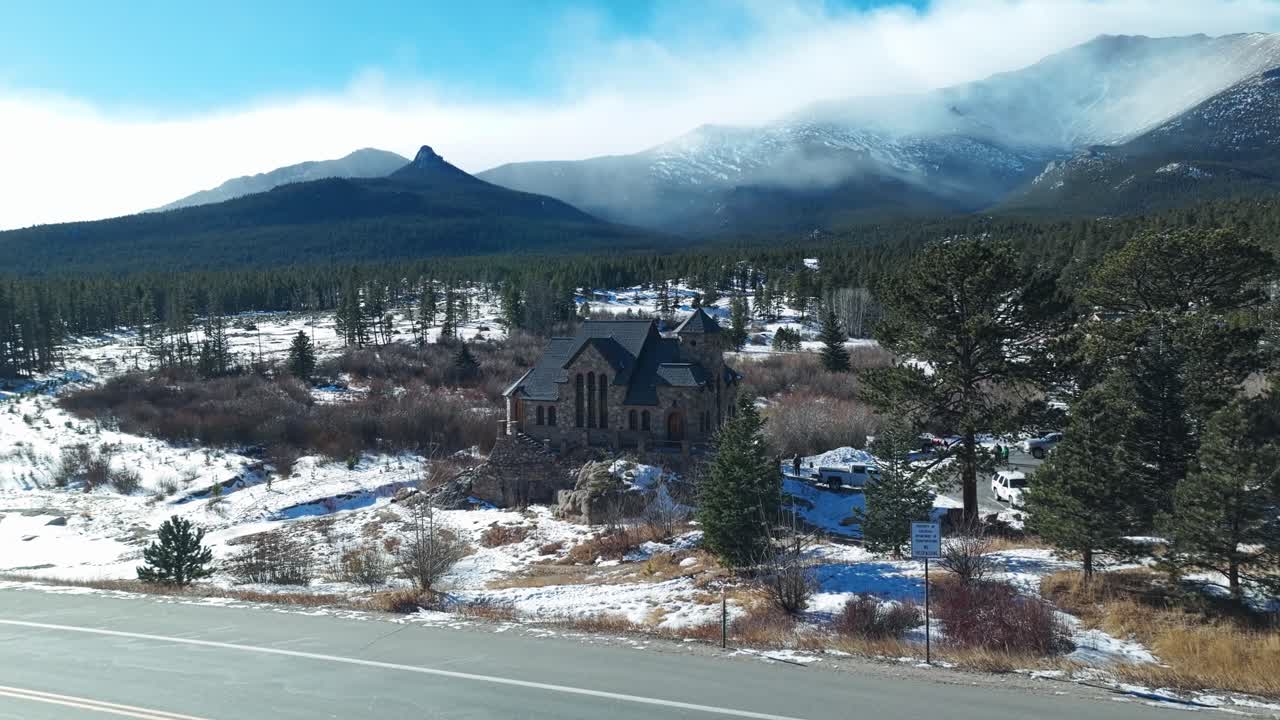 panorámica aérea que establece la capilla en la roca en allenspark en la base de la niebla de colorado picos de montañas rocosas con nubes