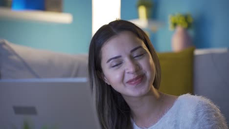 una joven feliz está usando una computadora portátil.