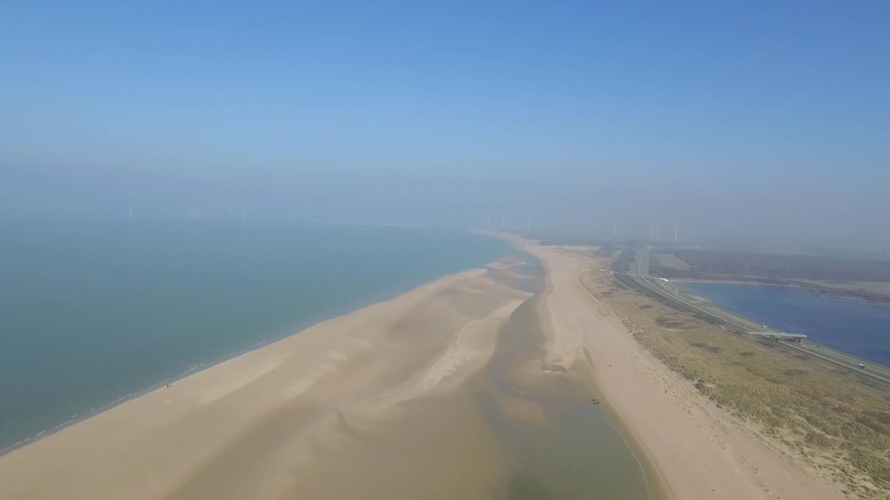 Aerial View of Coastline with Highway and Wind Farm