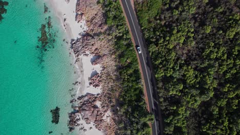 topdown aerial of car driving next to the crystal clear waters of eagle bay